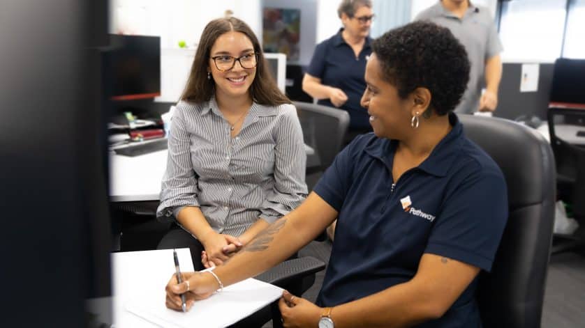 a consultant helps a job seeker with their job search seated at a desk