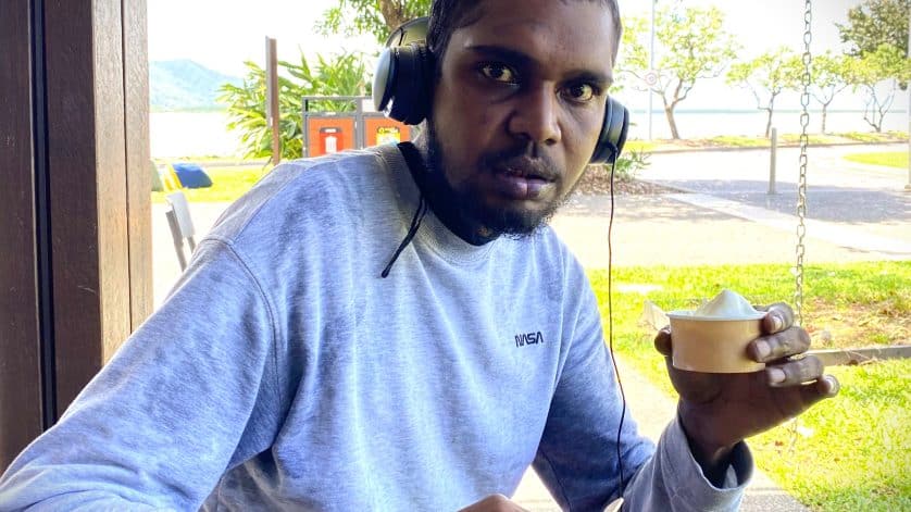 Waylon is growing his independence with our Disability Supports. In this picture he is sitting at an outdoor cafe enjoying icecream from a cup.