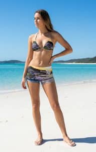 A woman stands on an iconic Whitsundays beach in Lucky Bums swimwear.
