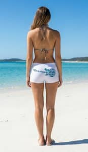 A woman stands on an iconic Whitsundays beach in Lucky Bums swimwear.