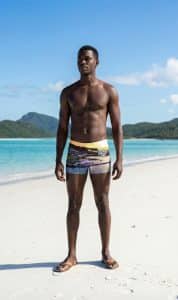 A man stands on an iconic Whitsundays beach in Lucky Bums swimwear.